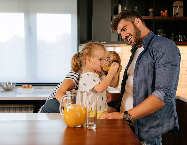 Family in kitchen with baby living comfortable lives with Jackson River Community Credit Union